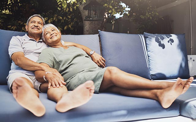 Retired couple relaxing on an outdoor couch