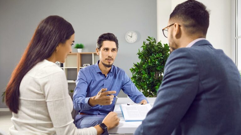 Investment specialist speaking with a couple in an office