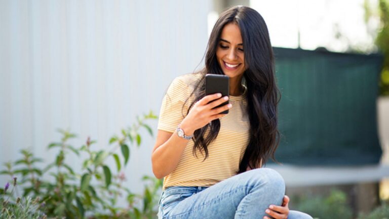 Young woman smiling on her smart phone