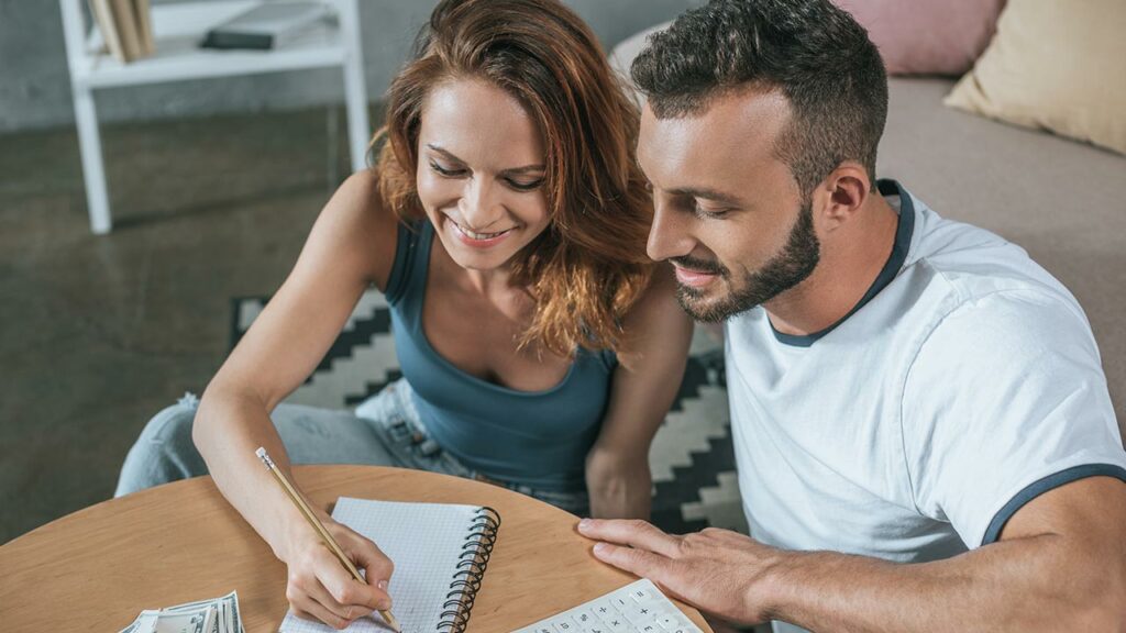 Couple doing financial planning on the floor of their living room