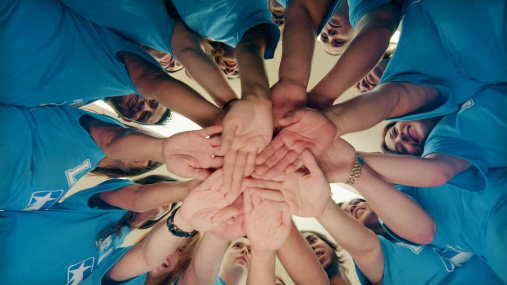 LSNB volunteers putting their hands in a circle